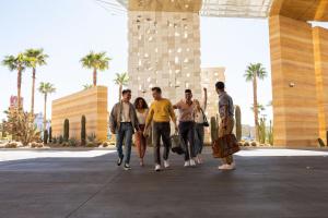 un groupe de personnes marchant devant un bâtiment dans l'établissement Virgin Hotels Las Vegas, Curio Collection by Hilton, à Las Vegas