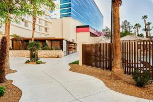 un trottoir devant un bâtiment avec une clôture dans l'établissement Virgin Hotels Las Vegas, Curio Collection by Hilton, à Las Vegas