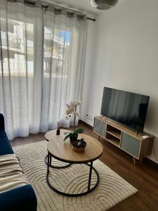 a living room with a tv and a coffee table at Splendide Appart’ près de Disney in Montévrain