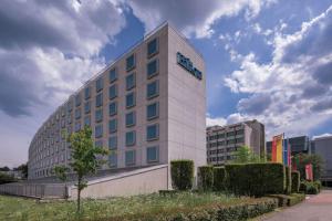 a hotel building with a sign on the side of it at Hilton Geneva Hotel and Conference Centre in Geneva