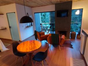 a living room with a table and chairs and a fireplace at Angatu chalé in Gonçalves