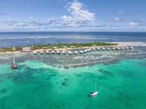 une île avec des parasols et un bateau dans l'eau dans l'établissement DoubleTree by Hilton Noumea Ilot Maitre Resort, à Ilot Maitre