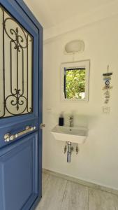 baño con lavabo y puerta azul en Blue Gem Villa, en Lefkada 18 fotos más