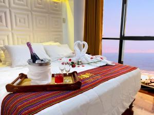 a tray with a bottle of wine and glasses on a bed at Inkari Apart Hotel in Lima