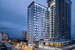 een hoog blauw gebouw met lichten aan bij Hilton Garden Inn Umhlanga Arch in Durban