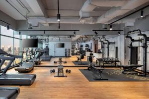 迪拜DoubleTree by Hilton Dubai M Square Hotel & Residences的健身房设有数台跑步机和机器