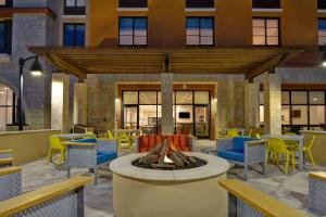 a patio with a fire pit in front of a building at Home2 Suites By Hilton Orlando Flamingo Crossings, FL in Orlando