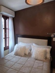 a bedroom with a large white bed with pillows at Infinit Home Duplex entero in Termas de Río Hondo