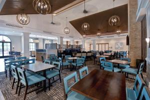 Homewood Suites By Hilton Orlando Flamingo Crossings, Fl في أورلاندو: غرفة طعام مع طاولات وكراسي زرقاء