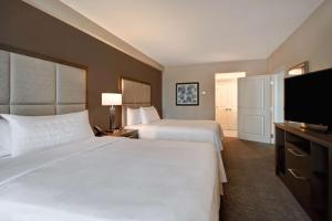a hotel room with two beds and a flat screen tv at Homewood Suites By Hilton Orlando Flamingo Crossings, Fl in Orlando