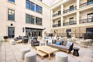 eine Terrasse mit Sofas und Tischen vor einem Gebäude in der Unterkunft Hilton Club Liberty Place Charleston in Charleston