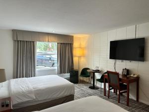 a hotel room with a bed and a desk and a television at August Jack Inn in Squamish