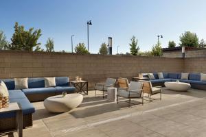 a patio with couches and tables and chairs at Hilton Alpharetta Atlanta in Alpharetta