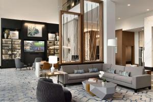 a living room with two couches and a table at Hilton Alpharetta Atlanta in Alpharetta