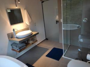 a bathroom with a sink and a glass shower at Angatu chalé in Gonçalves +24 photos