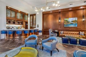 a bar with blue chairs and a couch in a room at Hilton Club Liberty Place Charleston in Charleston