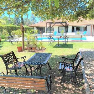 Tres bancos de parque y una mesa de picnic en un patio. en Casa Quinta con pileta Tortuguitas Bs As, en Manuel Alberti 28 fotos más