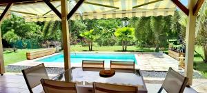 - une piscine avec une table et des chaises dans la cour dans l'établissement Cocooning Paradise, à Saint-François
