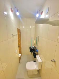a white bathroom with a toilet and a sink at Apartamentos C7 in Cunha