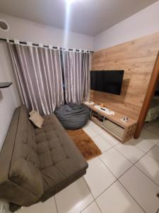 a living room with a couch and a flat screen tv at Apartamento centro Efapi ideal para trabalho ou estudo in Chapecó