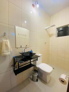 a bathroom with a white toilet and a sink at Apartamentos C7 in Cunha