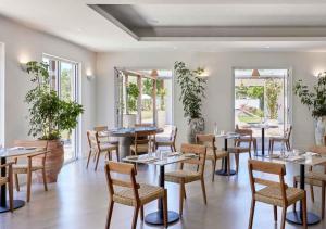 a dining room with tables and chairs and windows at Lancemore Milawa in Milawa