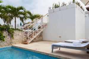 a villa with a swimming pool and a staircase at Nacar Hotel Cartagena, Curio Collection by Hilton in Cartagena de Indias