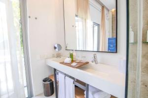 a bathroom with a sink and a mirror at Nacar Hotel Cartagena, Curio Collection by Hilton in Cartagena de Indias