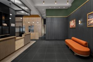 a kitchen with an orange bench in a room at Courtyard by Marriott New York World Trade Center Area in New York