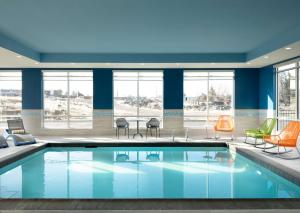 una piscina en una habitación de hotel con sillas y mesas en Hampton Inn Redmond Bend Airport, en Redmond