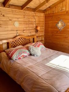 a bedroom with a bed in a wooden cabin at Cabaña en Pichidangui un Oasis de naturaleza y relajación in Pichidangui