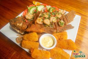 a plate of food with steak and shrimp and dipping sauce at Hotel del Bosque in Río Cuarto