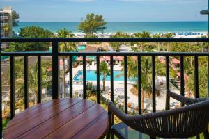 uma varanda com mesa e cadeiras e a praia em Hilton Garden Inn St. Pete Beach, FL em St. Pete Beach
