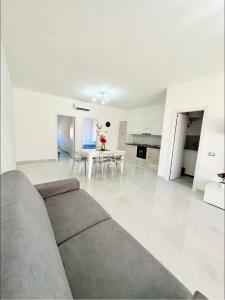 een witte woonkamer met een bank en een tafel bij Appartamenti vacanze in Cirò Marina