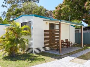 une petite maison blanche avec une table et des chaises dans l'établissement NRMA Treasure Island Holiday Resort, à Gold Coast
