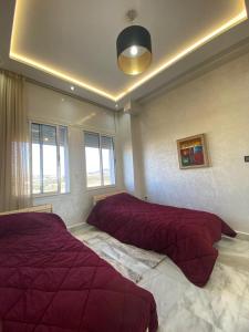 a bedroom with two beds with red comforters at luxury condo with sea view in Tangier
