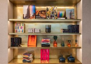 une étagère avec des livres, des vases et des livres dans l'établissement Motto by Hilton New York City Chelsea, à New York