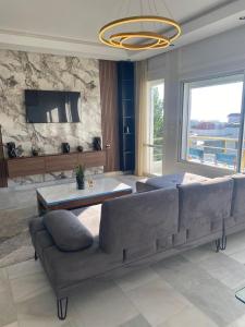 luxury condo with sea view في طنجة: غرفة معيشة مع أريكة كبيرة وطاولة