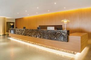 a lobby with a reception desk in a building at Almenat Embu Das Artes Sao Paulo, Tapestry Collection in Embu