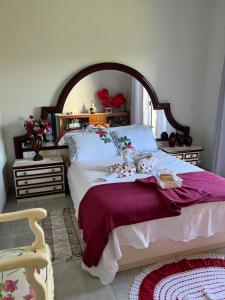 a bedroom with a large bed with a purple blanket at Jardim D’Jully in Santa Terezinha de Itaipu