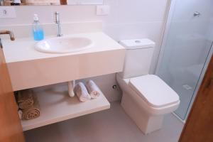Baño blanco con lavabo y aseo en Pousada Recanto Vô Fredo, en Guaratuba
