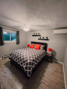 a bedroom with a black and white bed with red pillows at Sun Chaser Bay in Carrying Place