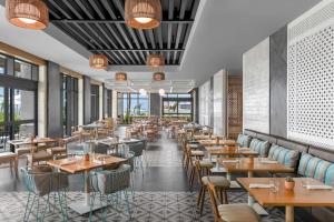 圖盧姆的住宿－Hilton Tulum Riviera Maya All-Inclusive Resort，餐厅设有木桌、椅子和窗户。