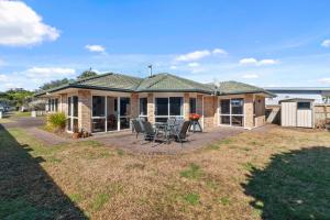 a home with a patio and a house at Fisherman's Friend - Bowentown Holiday Home in Waihi