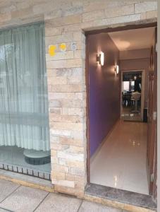 a building with a stone wall and a doorway at Infinit Home Duplex entero in Termas de Río Hondo