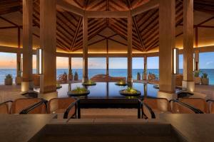 a dining room with a view of the ocean at Hilton Maldives Amingiri Resort & Spa in Male City