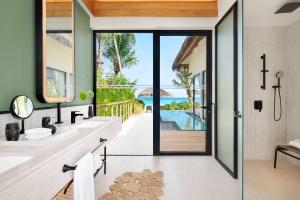 马累Hilton Maldives Amingiri Resort & Spa的一间带两个水槽的浴室,享有海景