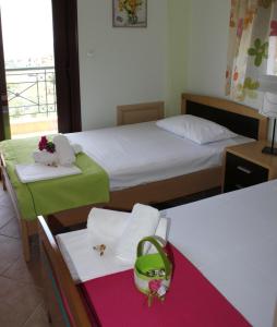 Habitación con 2 camas y mesa con cesta. en Sofia Luxury Maisonettes, en Nikiti