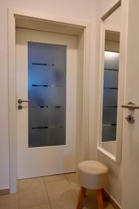 a bathroom with a door with a stool and a mirror at Modernes Apt mit direkter Anbindung zur City und Messe in Hannover