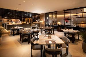 ソンナムにあるDoubleTree By Hilton Seoul Pangyo Residencesの木製のテーブルと椅子、キッチンが備わるレストラン